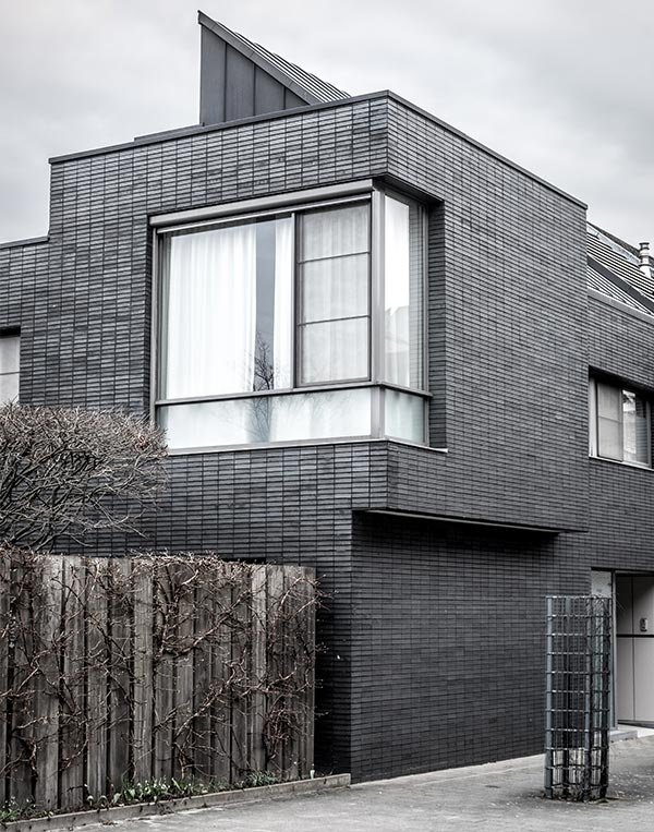 casa de fachada color negro de 2 pisos con ventana en una esquinera